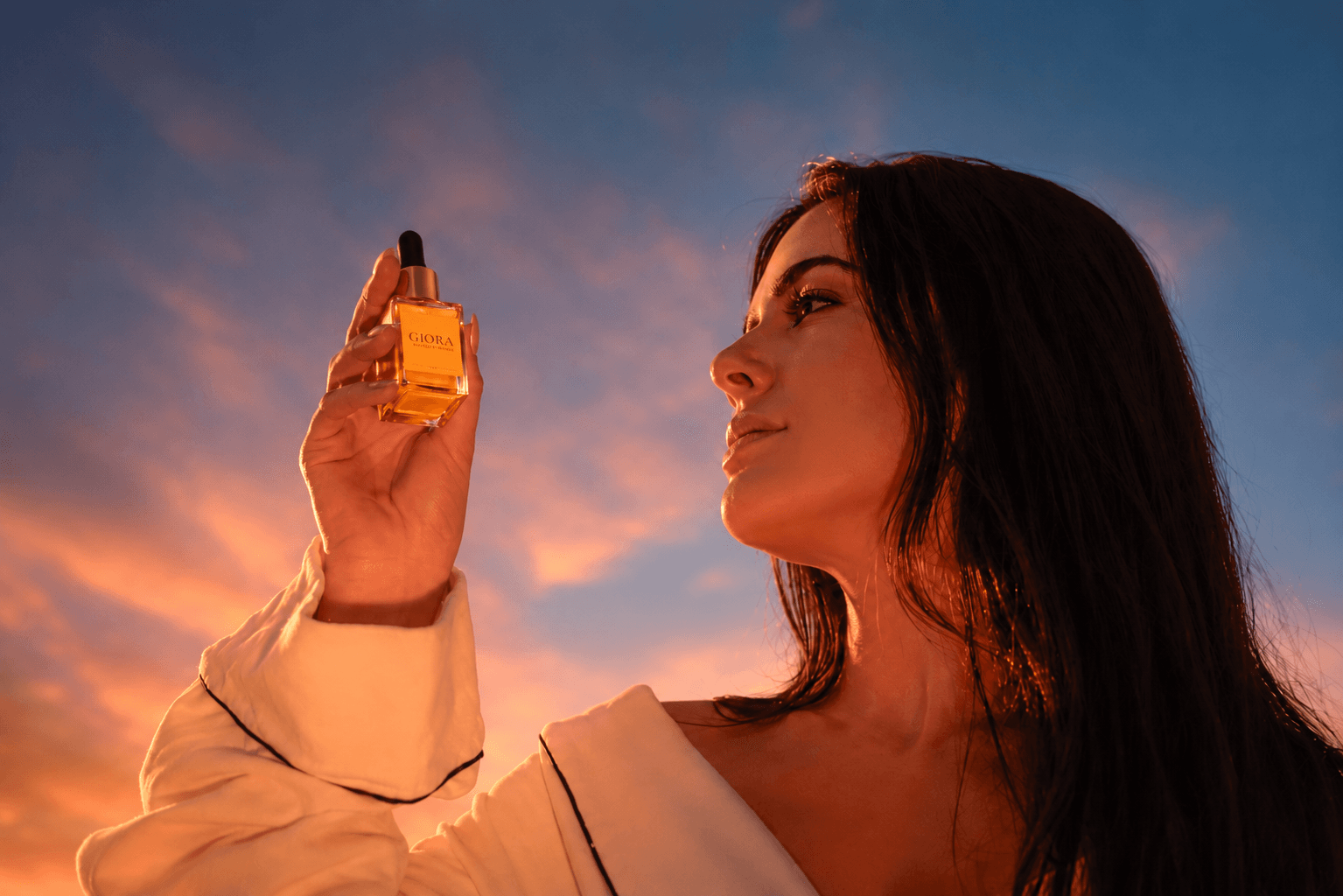 Sérum GIORA — modelo ao entardecer com frasco dourado